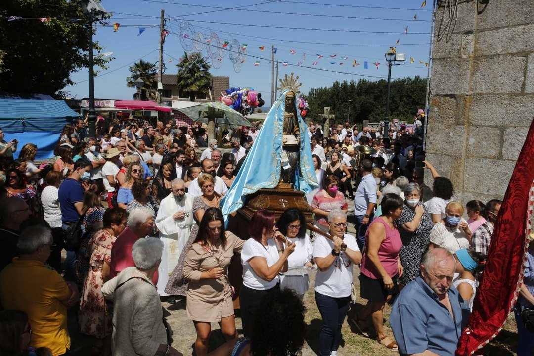 La figura de Santa Ana, rodeada de fieles mientras sale en procesión desde la iglesia de San Esteban de Beade.