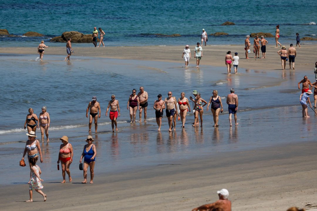 Bañistas paseando por la orilla del mar en la playa de Samil. // Jorge Santomé