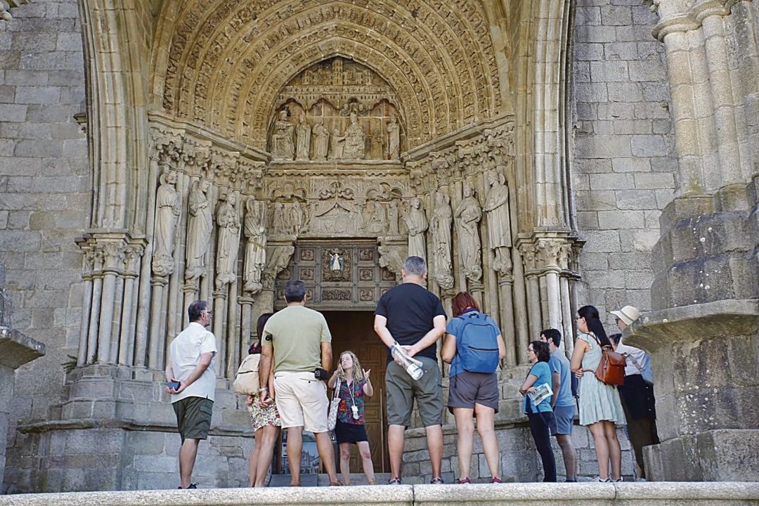 Un grupo de turistas conociendo la historia de la catedral de Tui con una visita guiada.