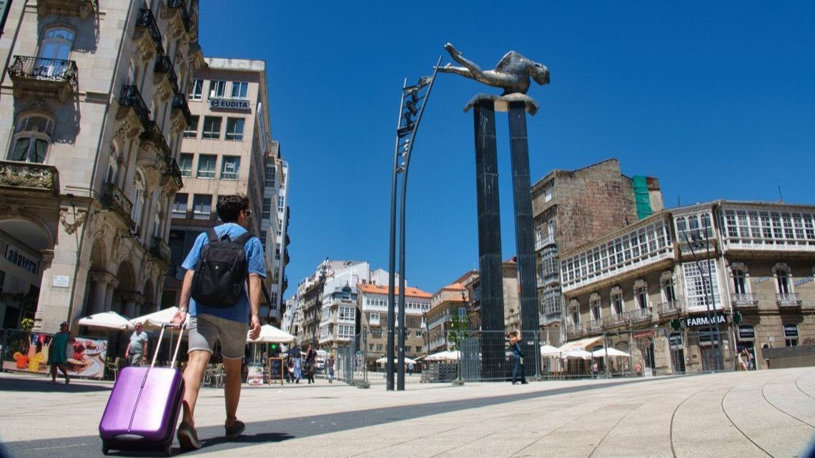 Un turista pasea con su maleta por la Porta do Sol, una imagen que se tornará habitual en el comienzo del verano.