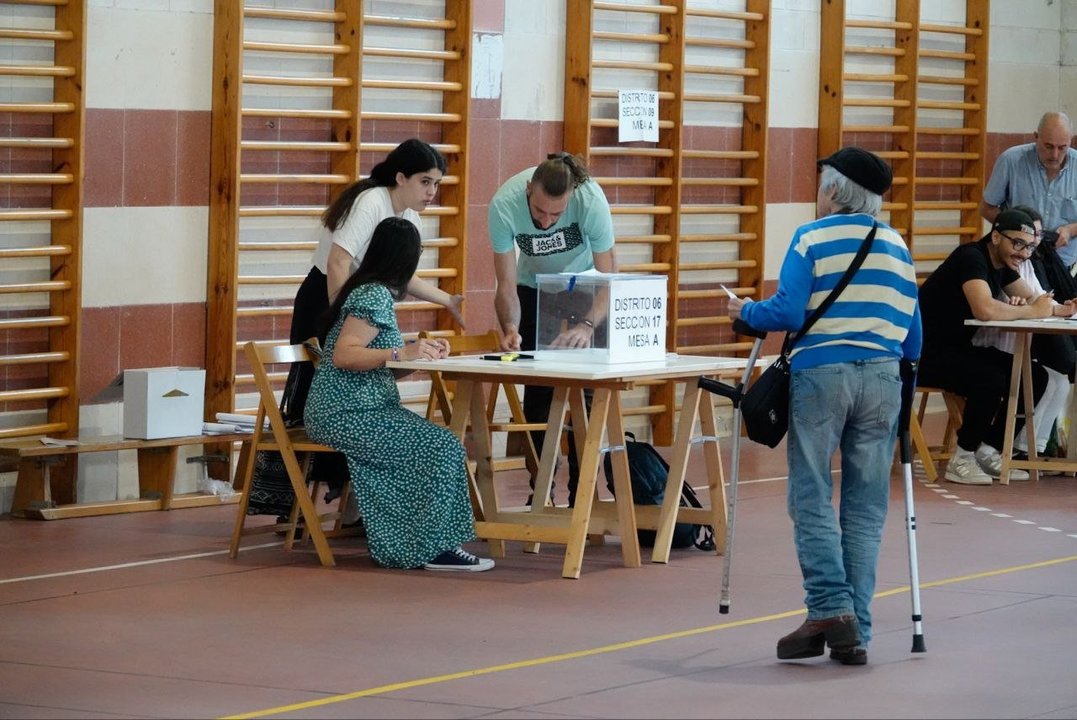 Un hombre busca su mesa para depositar su voto.