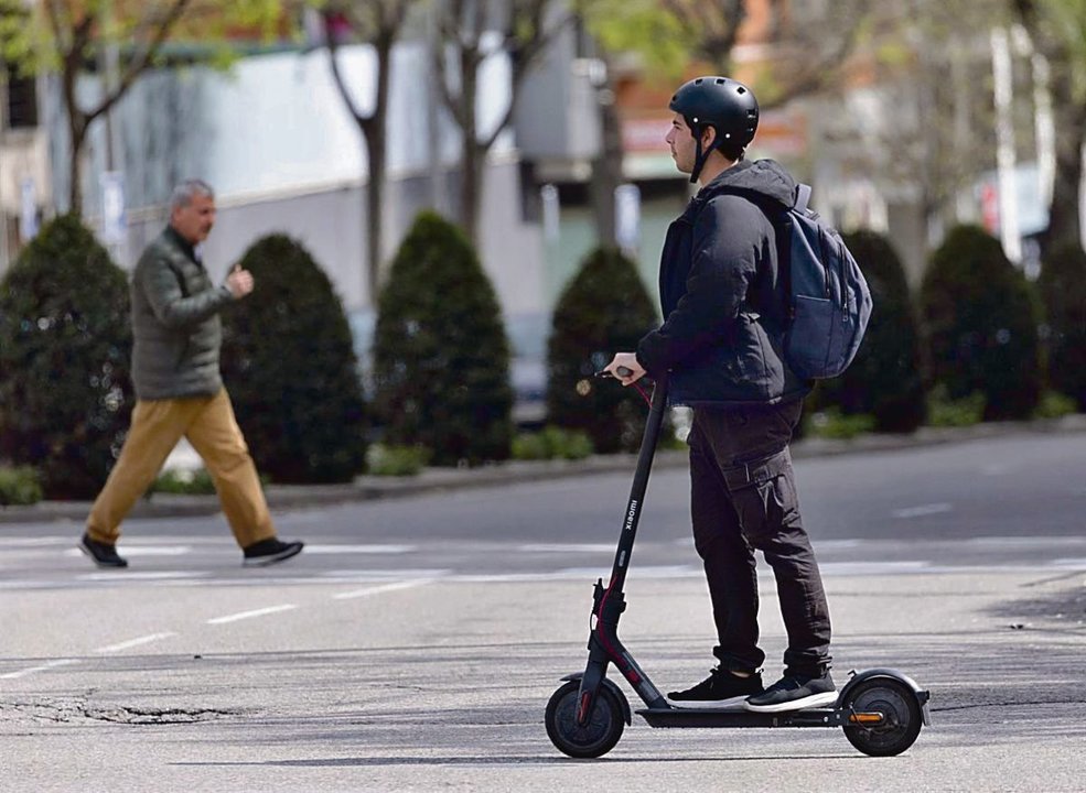 Un hombre utiliza un patinete eléctrico en una calle de Madrid.